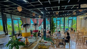 Ein Restaurant mit einer langen Theke, großen Fenstern und Holztischen.