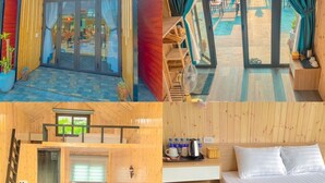 Eine Holzhütte mit Glastür, ein Balkon mit Blick auf den Garten, ein Bett mit Holz Kopfteil und eine kleine Küchenzeile.