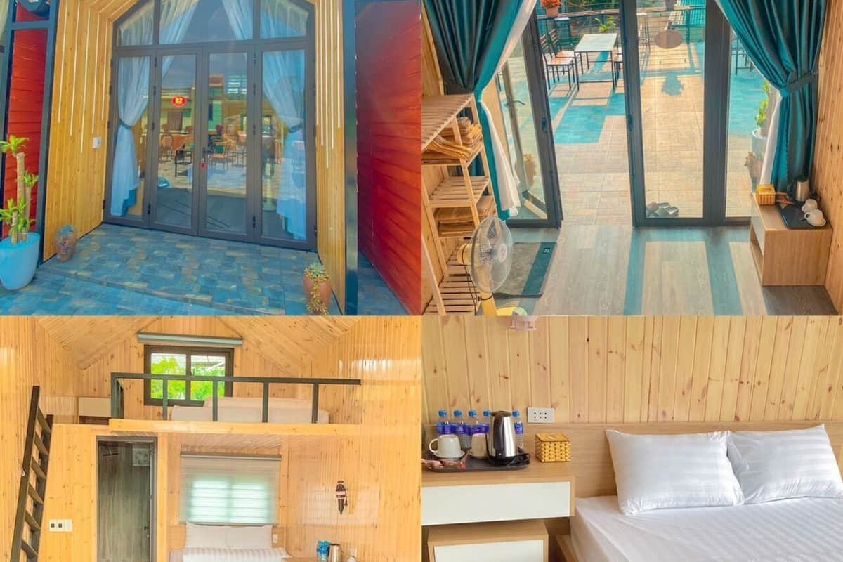 A wooden cabin with a glass entrance, a balcony with a view of the garden, a bed with a wooden headboard, and a small kitchenette.