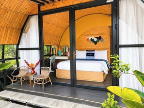 A room with a bed, a desk, and a chair. There is a window and a door. - Plum Hillside Lodge (Dong Van)