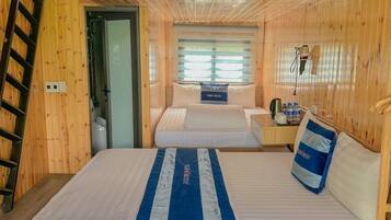 A bunk bed room with a loft bed, wooden walls, and a window with blinds.