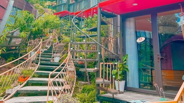 Eine Treppe führt zu einem Restaurant mit Außenbereich und Blumentöpfen.