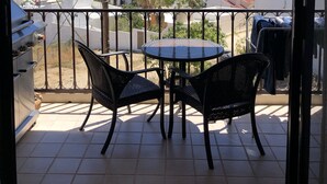 A balcony with a table and chairs, overlooking a coastal town with buildings and a view of the sea. - LaBamba - Great Condo for Adventurer in beautiful San Jose del Cabo (San José del Cabo)