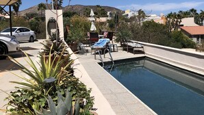 A pool area with lounge chairs, a small pool, and a view of a hilly landscape. - LaBamba - Great Condo for Adventurer in beautiful San Jose del Cabo (San José del Cabo)