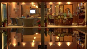 Un restaurante acogedor con zona de comedor, bar y pantalla de televisión.