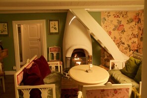 Una sala de estar acogedora con chimenea, una estructura blanca curva y papel tapiz floral.
