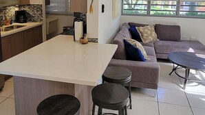 A modern kitchen with a central island, bar stools, a sofa, and a dining table. - ***CASA PALMA*** Tropical Caribbean Beach House (Rincon)