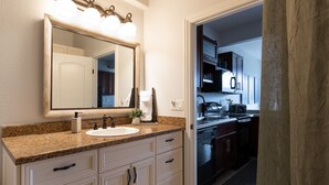 A bathroom with a sink, mirror, and vanity.