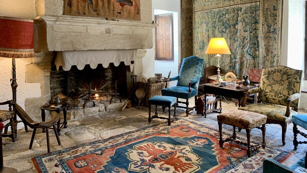 A traditional room with a fireplace, wooden furniture, and a patterned rug. - Waterfront manor house with heated pool (Baden)