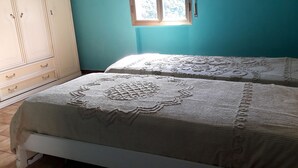 Two beds with intricate lace covers, a wooden wardrobe, and a window with natural light. - Easy Lake vacation home (Bargi)