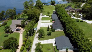 Vue aérienne d’un quartier résidentiel avec des maisons, des pelouses et une étendue d’eau.
