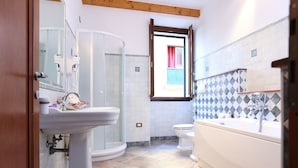 Une salle de bain équipée d’une douche, de toilettes, d’un lavabo et d’une baignoire.