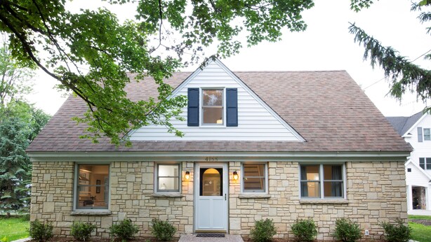 A stone house with a white door, two windows with shutters, and a small porch. - Centrally Located DoCo Oasis (Fish Creek)