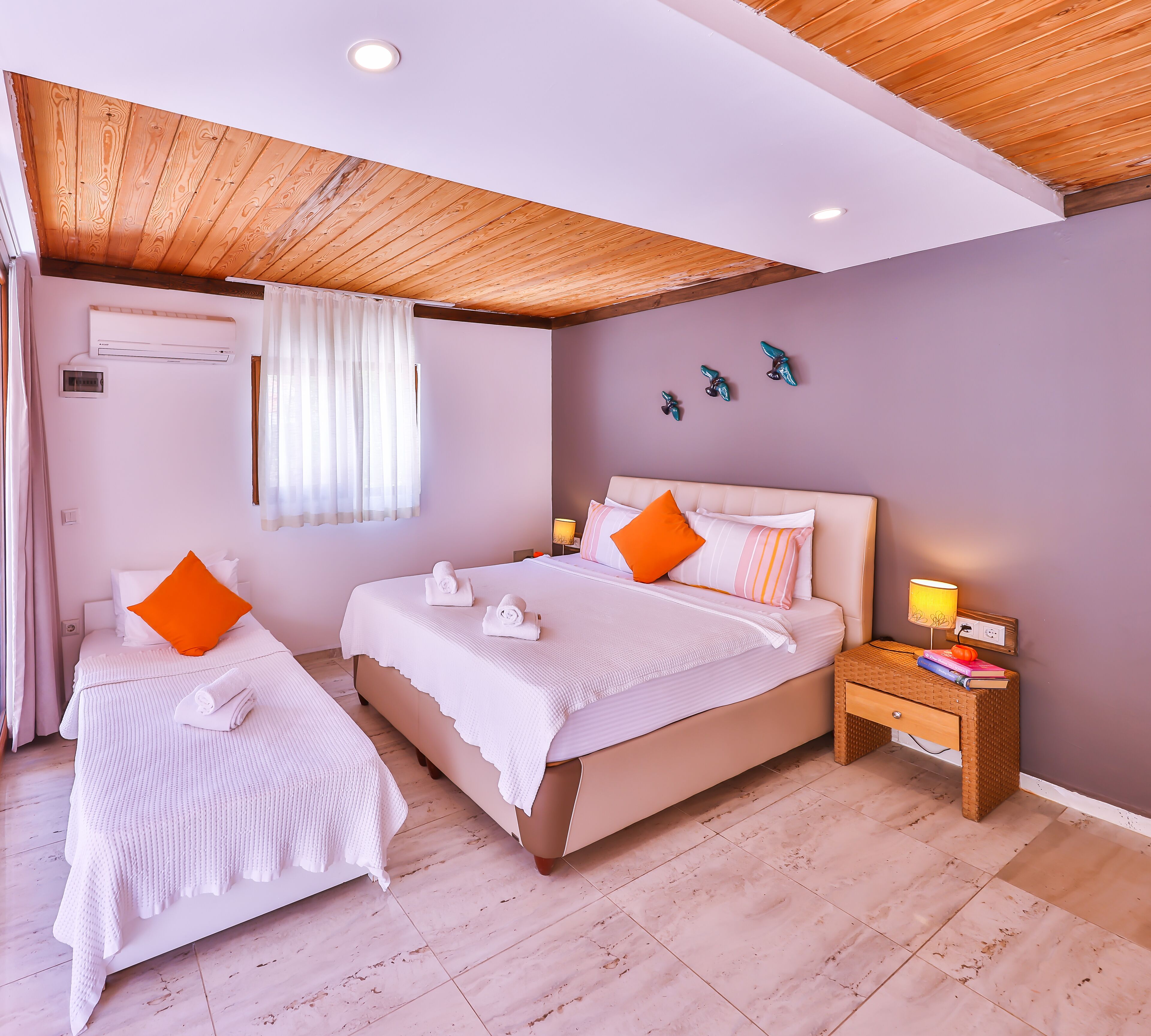 Een slaapkamer met twee bedden, een nachtkastje en een plafondventilator.