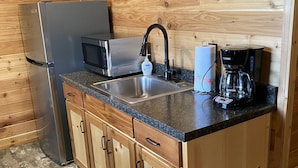 A compact kitchen with a stainless steel refrigerator, a microwave, a sink, and a coffee maker. - 1 Bedroom Cabin w/Two Recliners Cabin 7  (Hamilton)