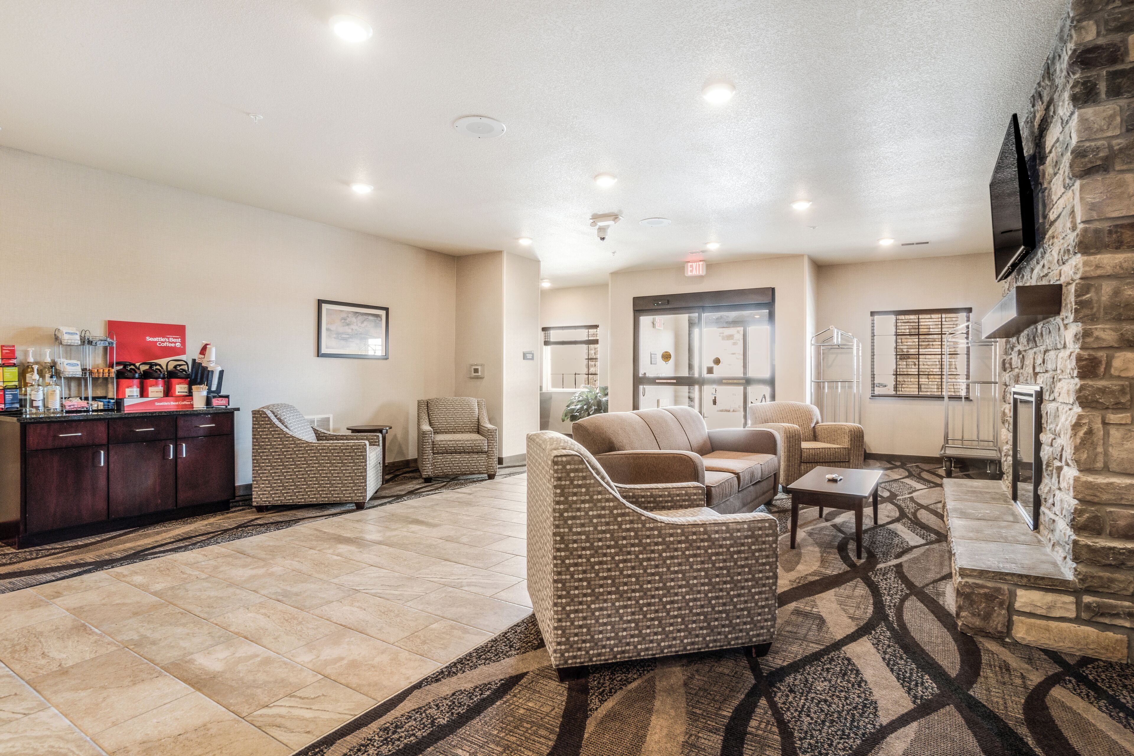 A lobby with a reception desk, seating area, and a fireplace.
