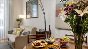 Una tavola imbandita con diversi cibi, un vaso con fiori e un quadro appeso al muro.