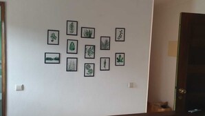 Eine Wand mit gerahmten Pflanzenabbildungen, die in einem Raster angeordnet sind.