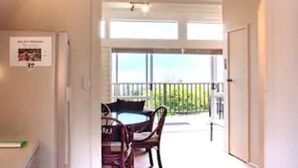 Cucina e sala da pranzo open space con vista su un balcone.