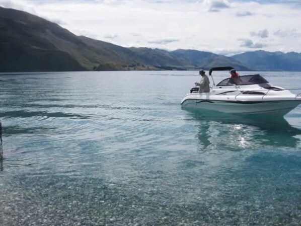 A boat on a calm lake with mountains in the background.