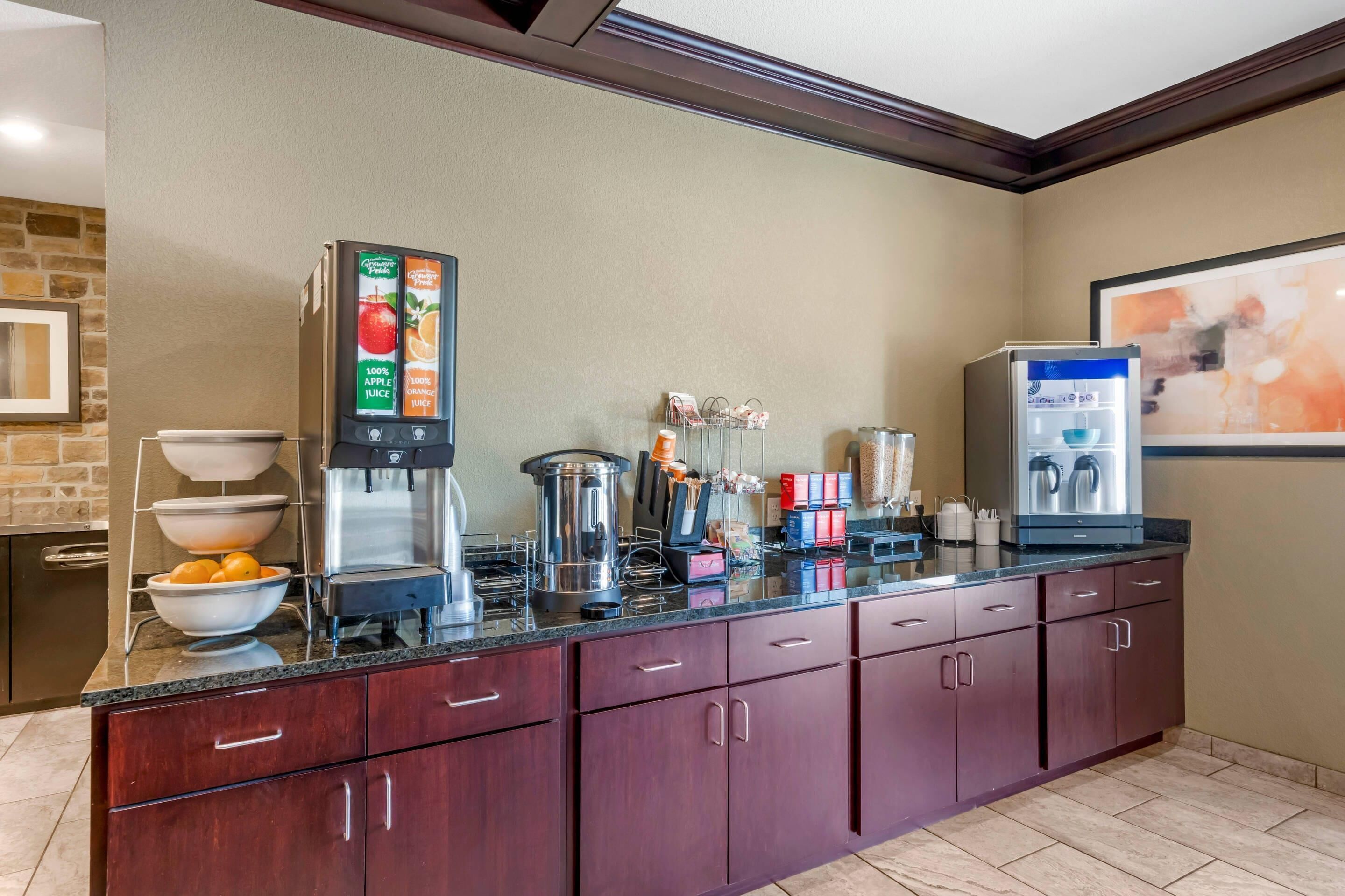 Una cocina con estación de café, hervidor y dispensador de agua.
