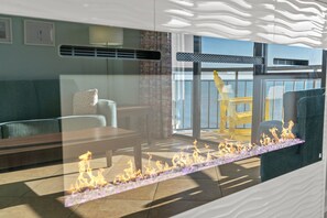 Un salon moderne avec une cloison en verre, un canapé, une table et une vue sur la mer.