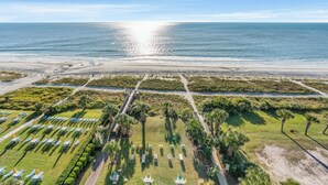 An aerial view of a coastal resort with a beach, rows of sun loungers, and a well-maintained lawn area. - 10th Floor 1br Oceanfront w/ Spectacular Views! (Myrtle Beach)