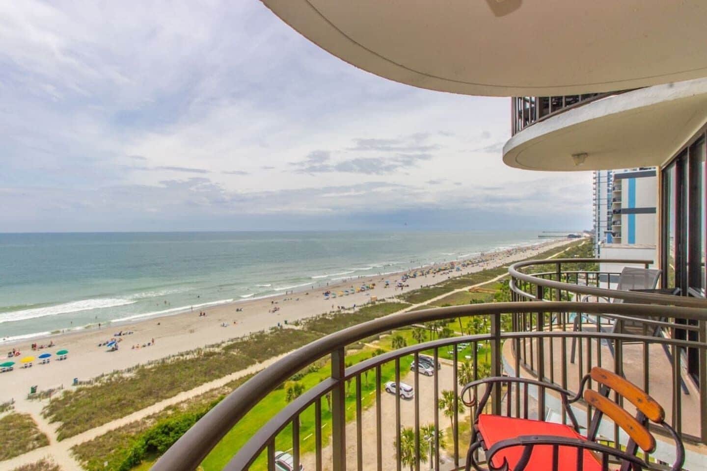 Ein Balkon mit Blick auf Strand und Meer.