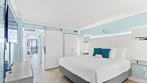 A bedroom with a bed, a desk, a wardrobe, and a door leading to a balcony. - 10th Floor 1br Oceanfront w/ Spectacular Views! (Myrtle Beach)