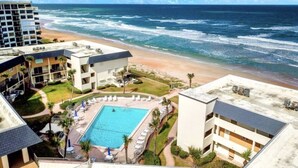 A beachfront hotel with a swimming pool, beach access, and ocean views. - Direct Oceanfront 1/1 king first floor, oceanfront Patio, pool beach steps away. (Ormond Beach)