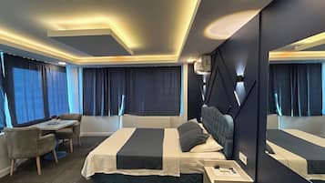A modern hotel room with a large bed, bedside tables, a desk, and a chair.