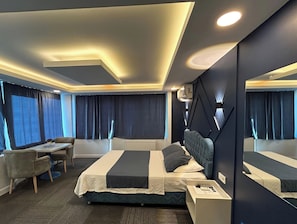 A modern hotel room with a bed, a desk, and a chair. - Kavacık Asia Hotel (Beykoz)