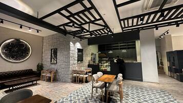 Un café con paredes de piedra, muebles de madera y un piso con diseño.