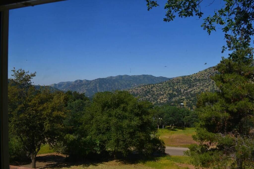 A view of a mountainous landscape with trees and a clear sky.