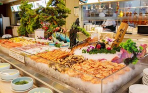 Un présentoir de fruits de mer, avec différents types de produits de la mer, notamment des crevettes et des homards, disposés sur de la glace.