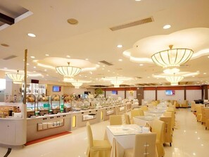 A hotel dining area with multiple tables and chairs, a buffet counter, and modern ceiling lights. - Guangzhou Nanmei Osotto Recreation Hotel (Guangzhou)