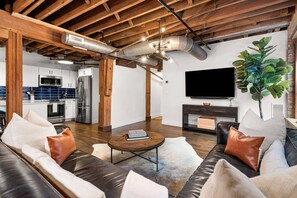 A modern living room with a fireplace, leather sofa, and a flat-screen TV.