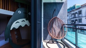 A modern room with a unique design, including a large plush toy and a wicker chair by a balcony with a view. - Songfeng Qinzi Homestay (Wujie)