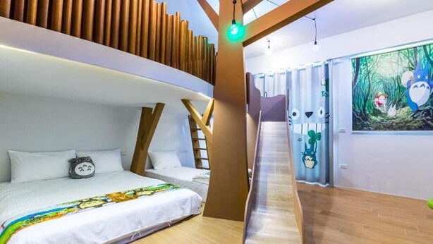 A bedroom with a bunk bed, a ladder, a bed with a colorful blanket, and a wall with a forest-themed painting. - Songfeng Qinzi Homestay (Wujie)