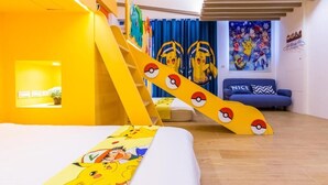 A room with a bed featuring Pokémon-themed bedding, a yellow slide, and a blue couch with a Pokémon-themed pillow. - Songfeng Qinzi Homestay (Wujie)