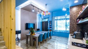 A modern kitchen with a built-in stove, a dining area with a table and chairs, and a staircase leading to another level. - Songfeng Qinzi Homestay (Wujie)