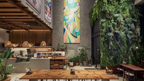 A modern bar area with a wooden counter, stools, and a large vertical garden. - Anteroom Seoul (Seoul)