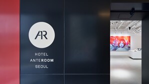 A hotel anteroom with a modern design, featuring a large AR logo and a vibrant artwork on the wall. - Anteroom Seoul (Seoul)