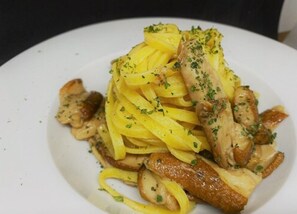 A plate of pasta with chicken and mushrooms. - Hotel La Place (Rome)