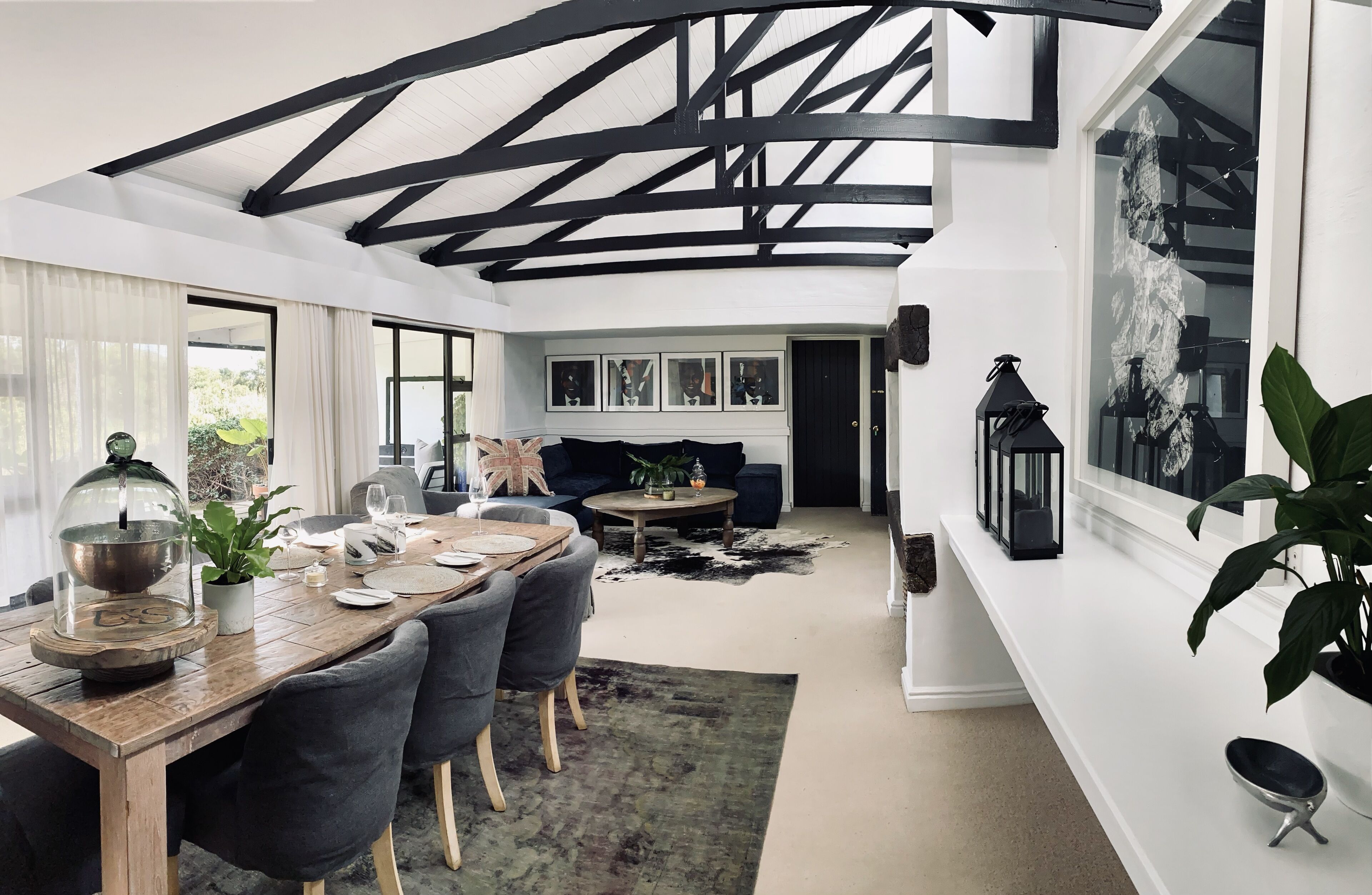 A modern dining area with a wooden table, chairs, and a glass dome centerpiece.