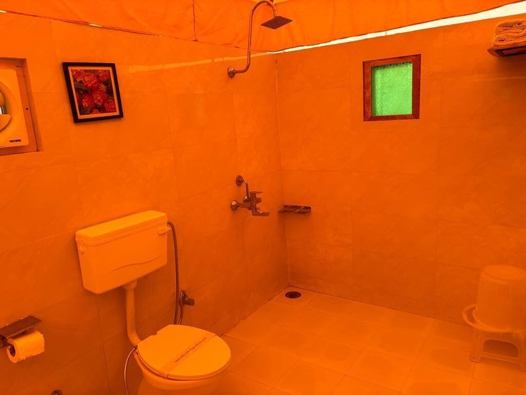 Un baño con inodoro, ducha y una pequeña ventana.