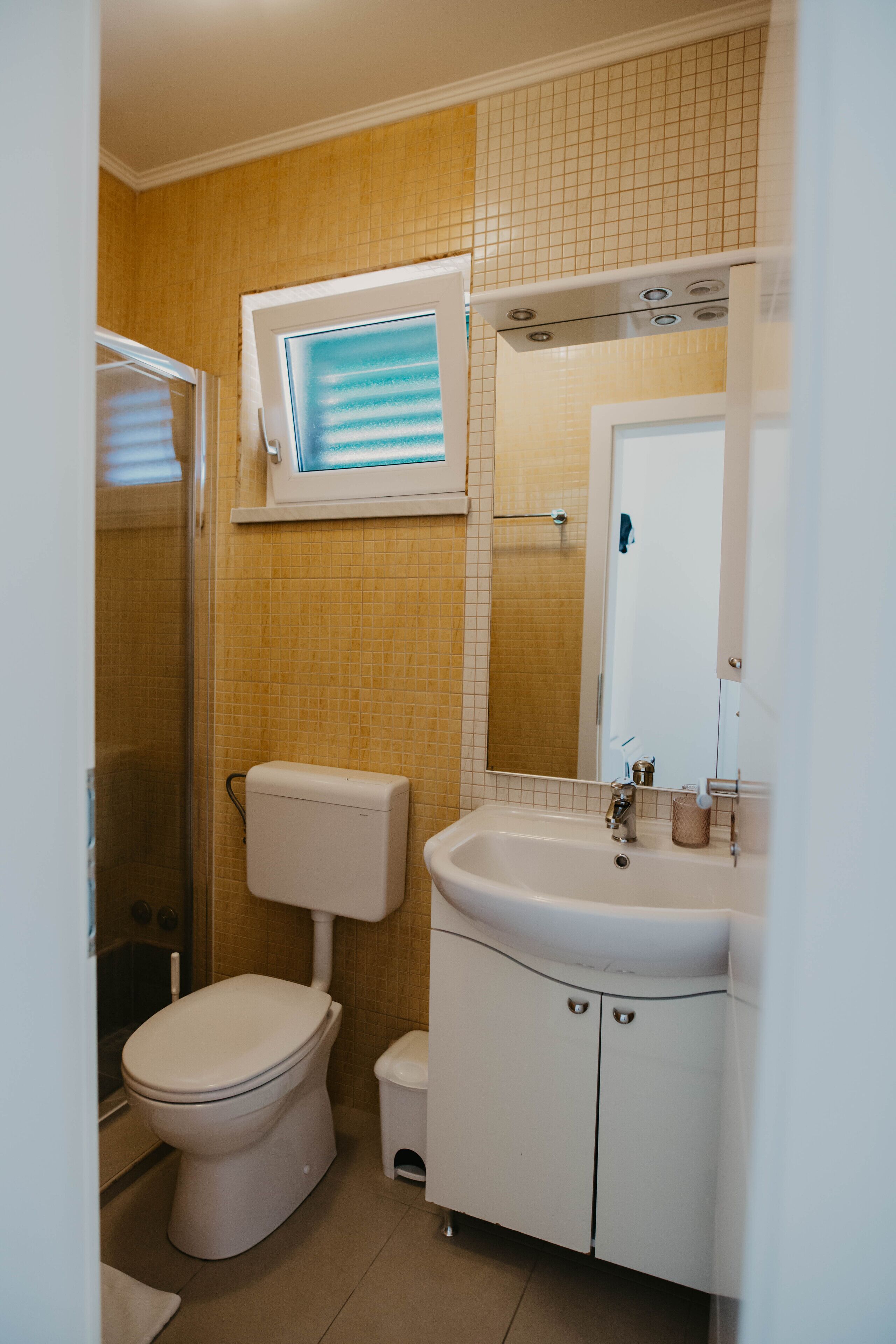 A bathroom with a toilet, sink, and shower.