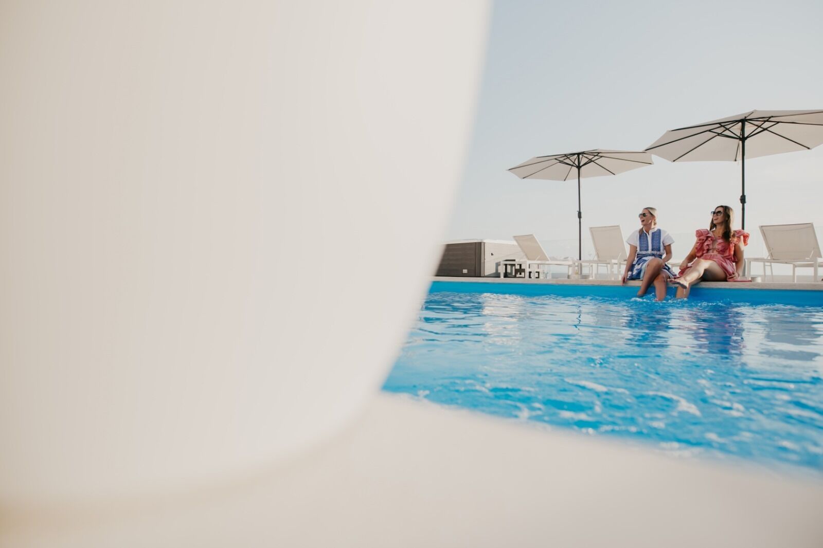 A pool area with lounge chairs and umbrellas.