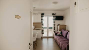 Apartamento Deluxe (3) | Zona de estar | Una televisión de pantalla plana, una mesa de tenis de mesa, juguetes