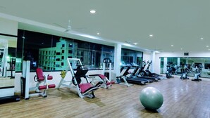Een sportschool met cardioapparatuur, gewichthefapparatuur en een grote fitnessbal.